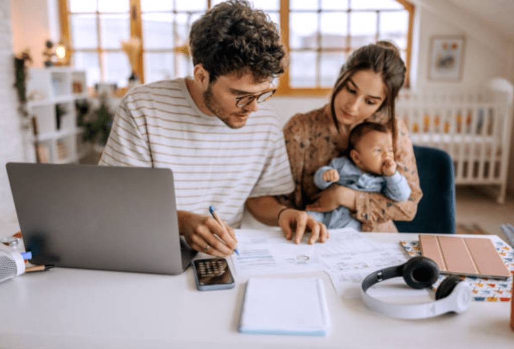 family holiday budget man and woman with baby looking at papers featured image